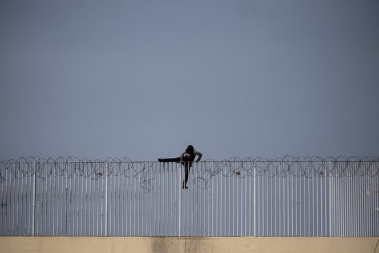 An unaccompanied minor attempting to make his way over the Ceuta border wall (Courtesy of Pedro Armestre/Save the Children)